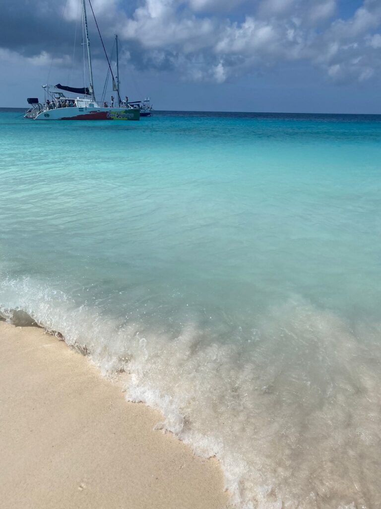 On the beach at Klein Curaçao island with a catamaran in the background.